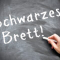 Bild einer schwarzen Tafel, wo eine Hand zu sehen ist, die das Wort "Schwarzes Brett!" schreibt
